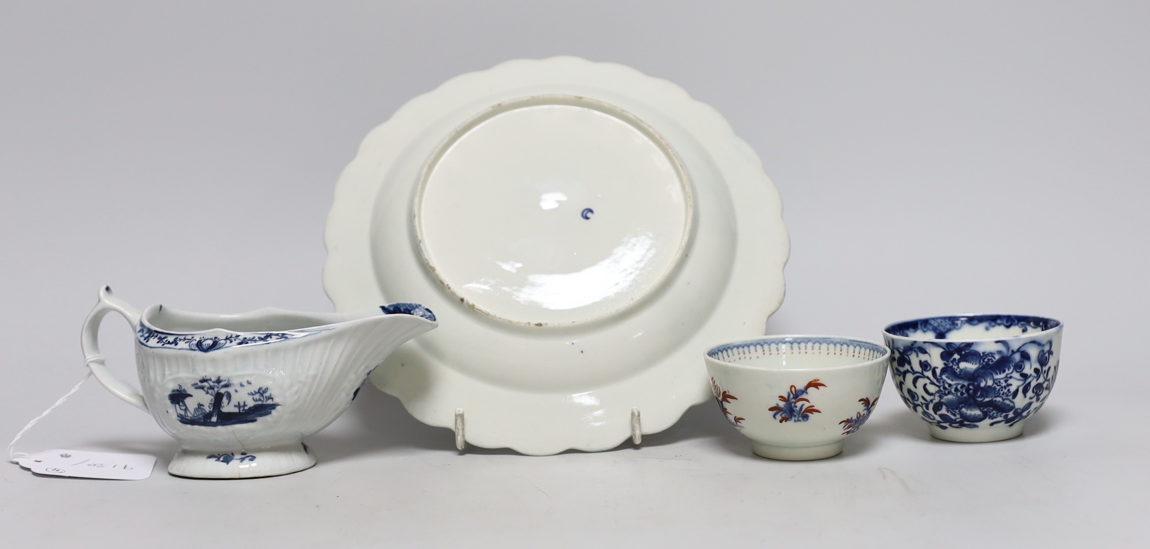 An 18th century Lowestoft sauceboat and a Worcester pine cone pattern plate and two tea bowls, dish 21cms diameter